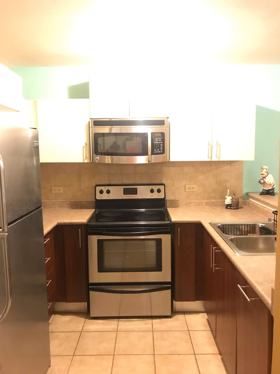 Fully equipped kitchen, refrigerator, stove, microwave, water sink.