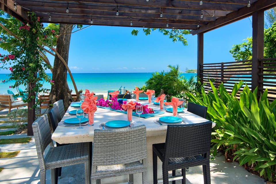 Dine alfresco beneath the pergola with the Caribbean Sea just beyond.