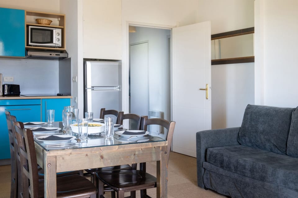 Turquoise cabinets add color to the living space, anchored by a comfortable sofa.