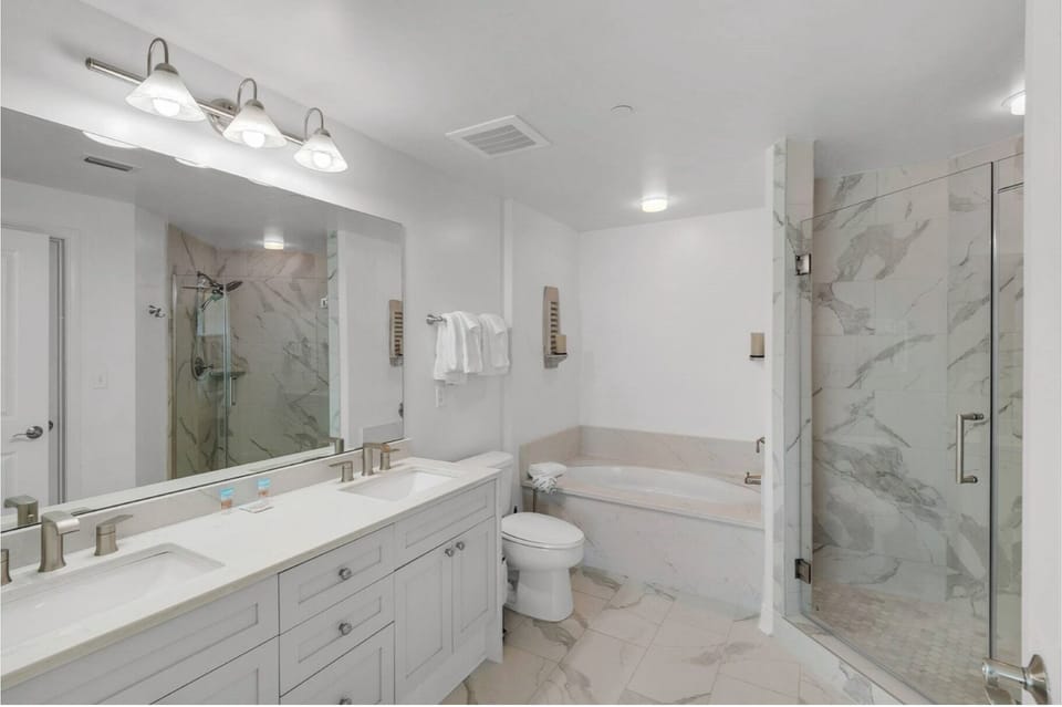 Unwind in your luxurious marble bathroom with a deep soaking tub, rainfall shower, and elegant dual vanity - your personal spa awaits.