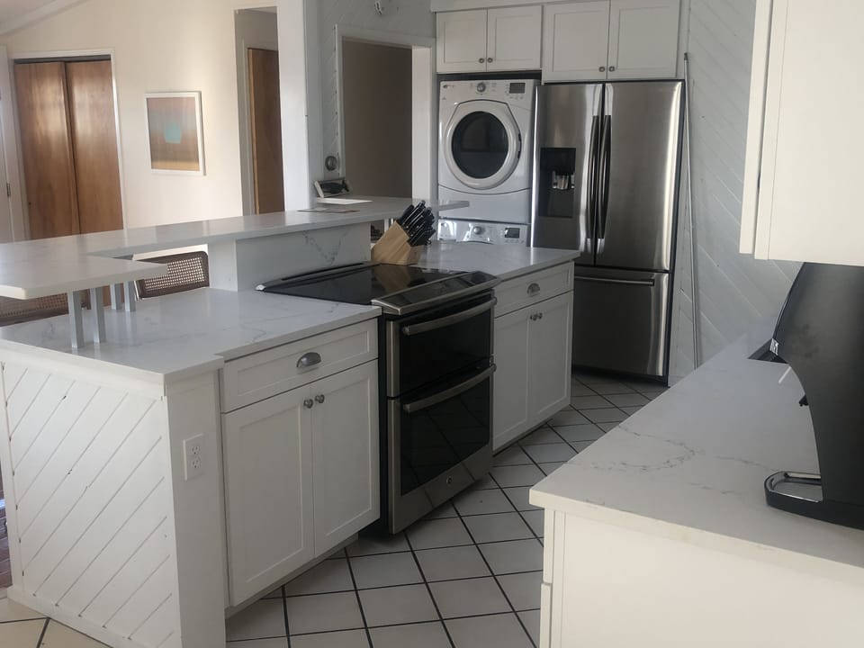 Kitchen, with washer dryer in view next to refrigerator. Bosche dishwasher.