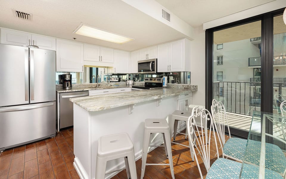 Embrace your beach vibe while preparing meals in this inviting kitchen, catching glimpses of coastal charm