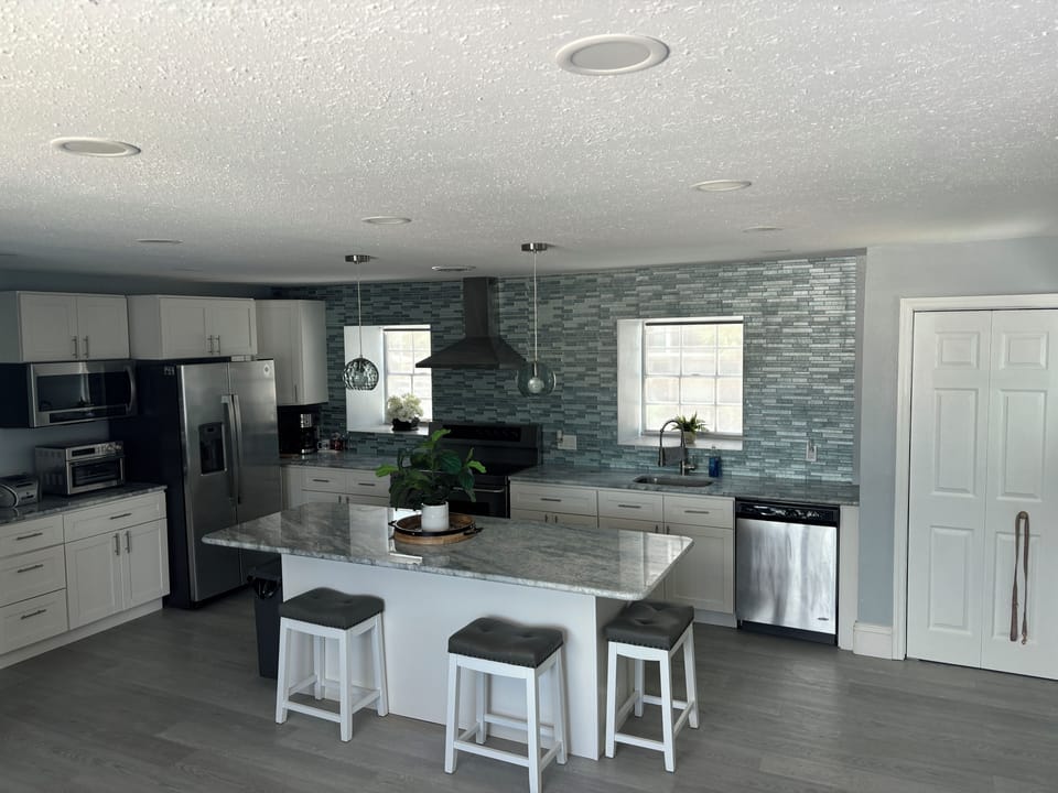 Eat in kitchen area with marble countertops and stainless steel appliances