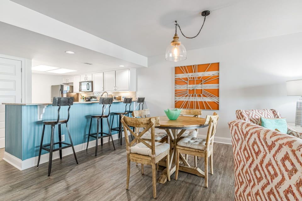 Fully equipped kitchen with white cabinets and breakfast bar at Wind Drift 209 SW