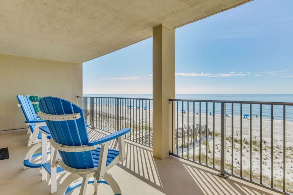 Covered balcony with blue outdoor chairs overlooking Gulf at Wind Drift Orange Beach