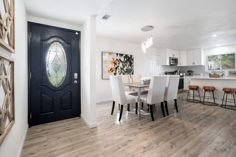 Dining area that can seat 6 people and kitchen countertop with 3 stools available.