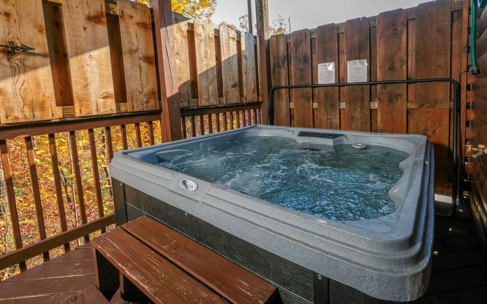 Private hot tub with autumnal forest views for serene mountain moments.