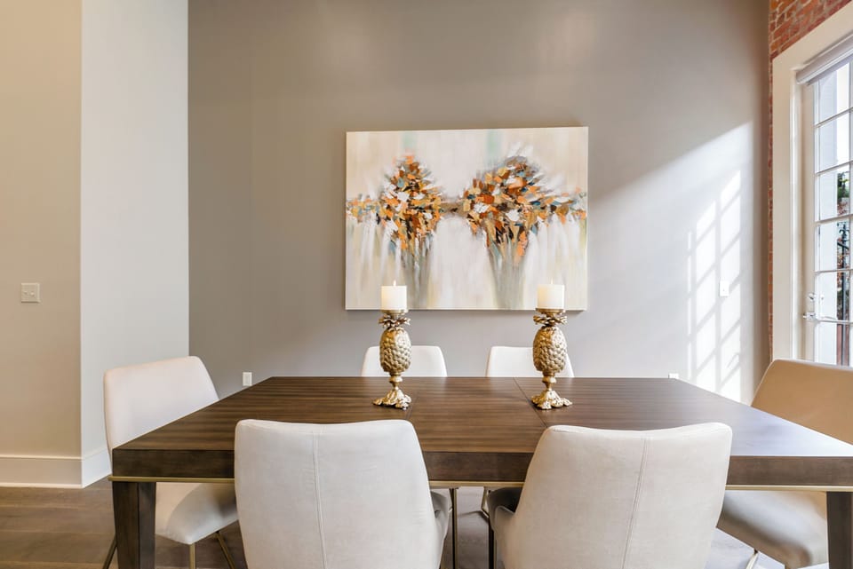 Open-concept living, kitchen, and dining area with ample seating. Relax on a large sectional and enjoy a 65” Samsung Smart 4K TV with streaming and DIRECTV Entertainment. Dining table seats six, plus bar seating for four. Plenty of natural light!
