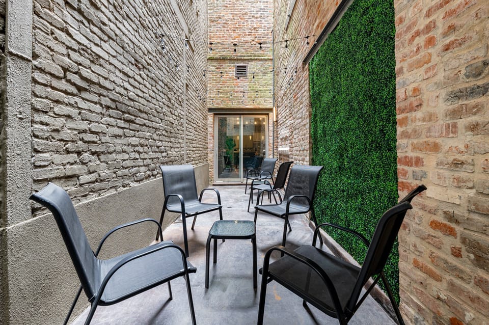 Private patio with seating, string lights, and greenery
