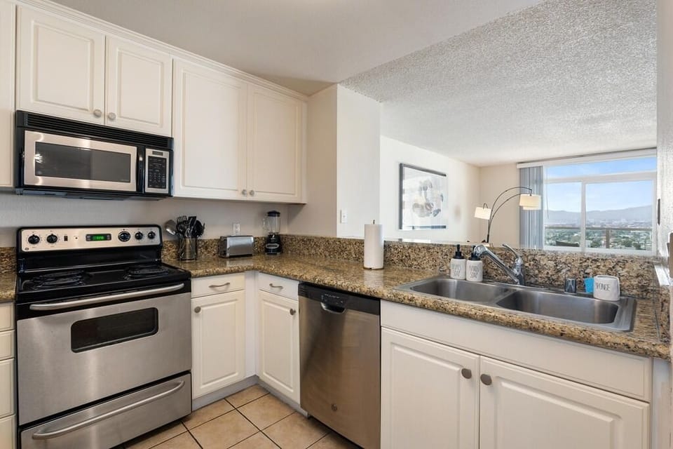 Fully stocked kitchen features granite counters and stainless steel appliances.