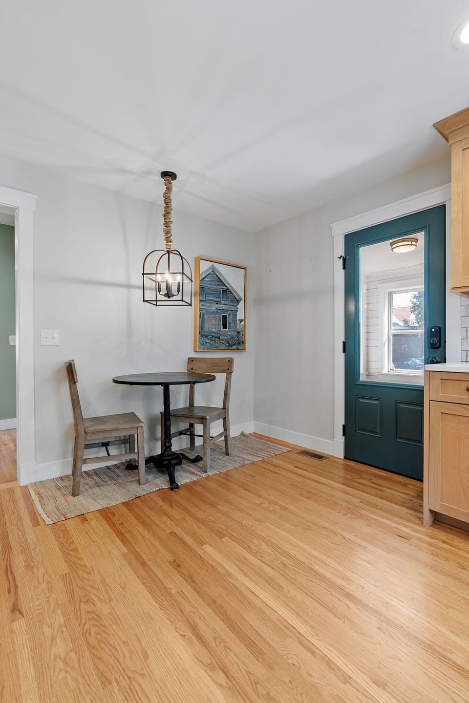Step into your charming dining nook where warm wood floors meet stylish lighting, creating the perfect spot for morning coffee or intimate meals.