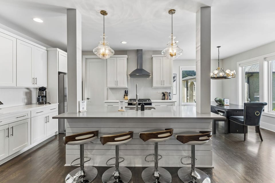 Gather around the quartz island — bar seating for four, gas range behind, and everything a group of ten needs to cook together.