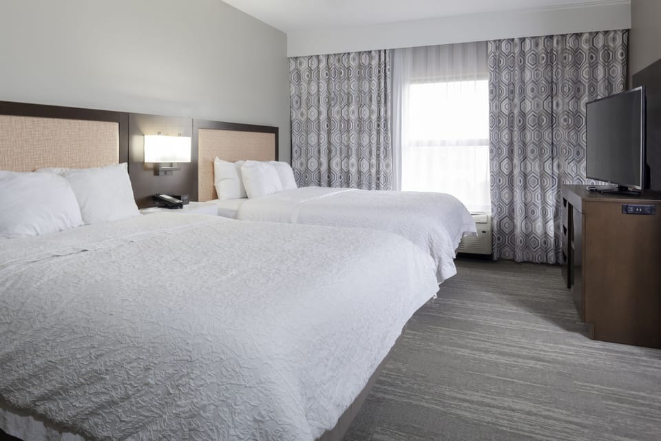 Premium bedding, desk, laptop workspace, blackout drapes
