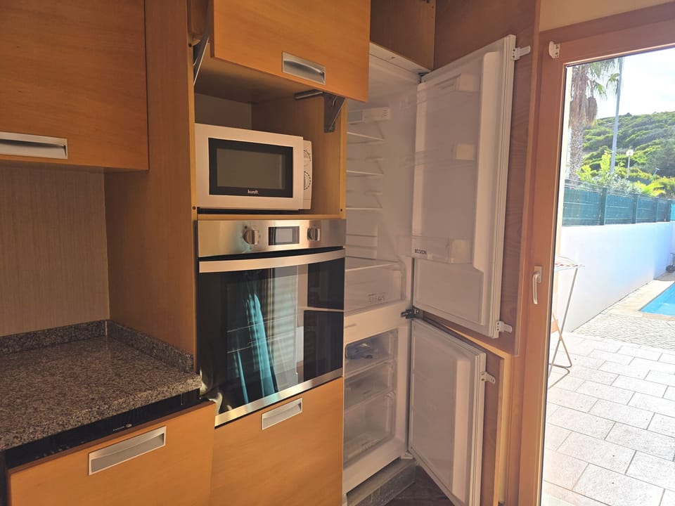 Kitchen with fridge doors open,  has direct access to the pool area