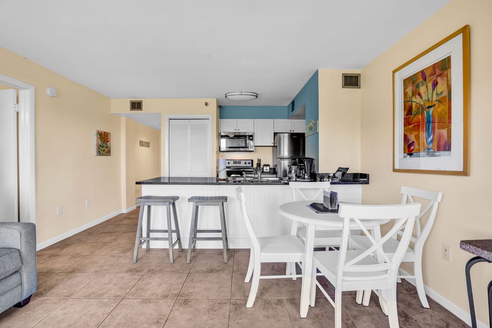 Open living area with dining room table and bar stools