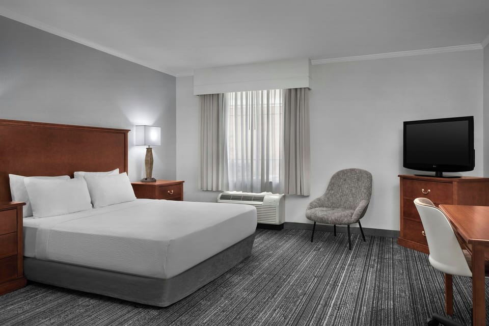 Premium bedding, desk, laptop workspace, blackout drapes