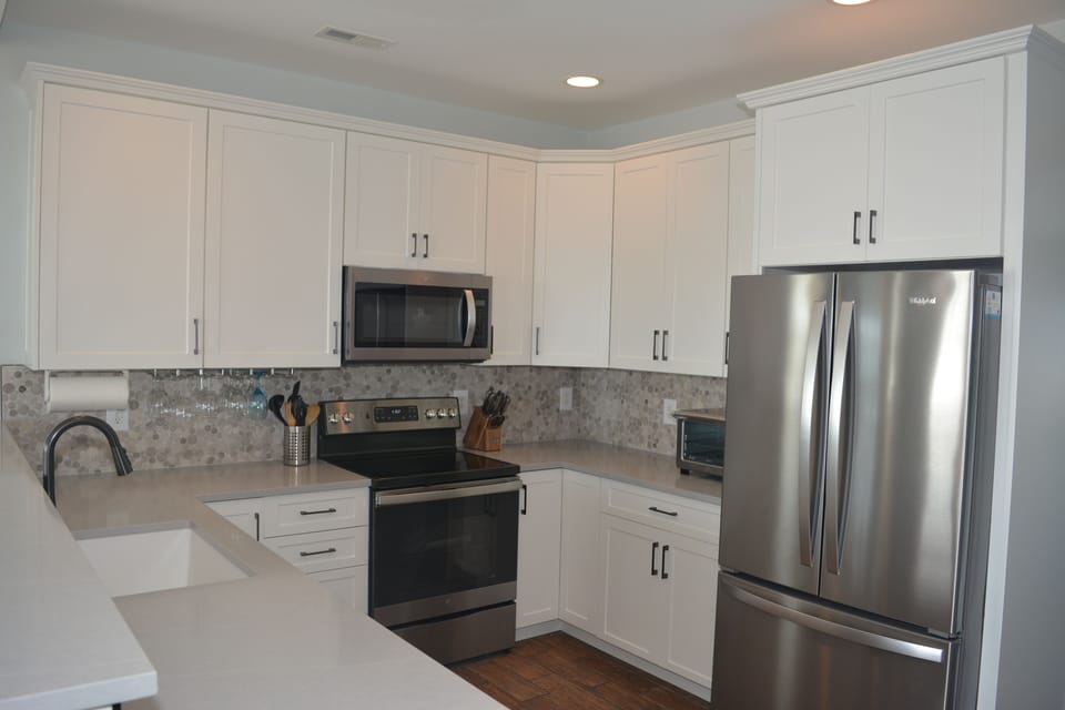 Updated kitchen with generous cabinets and stone counters. 