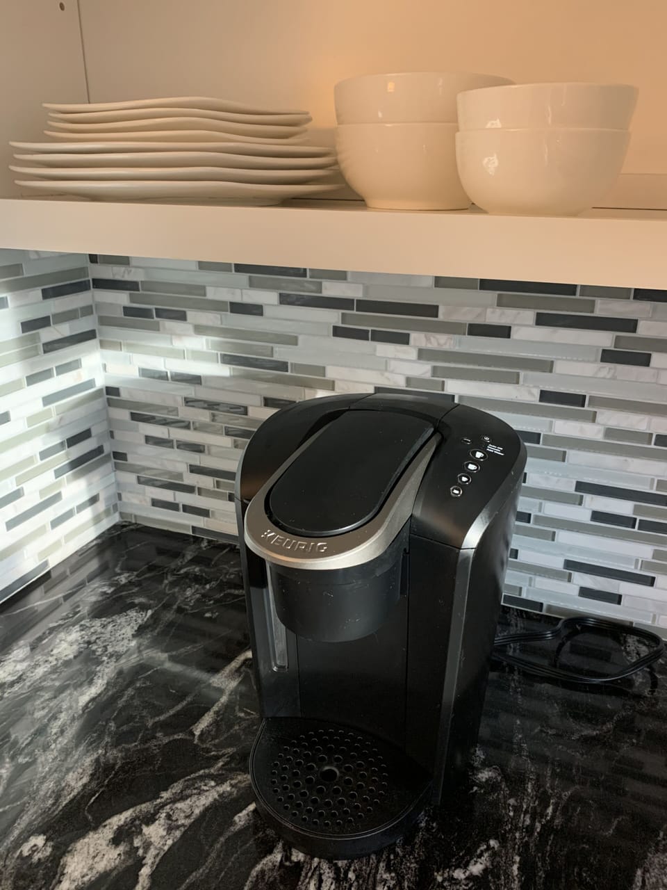 Kitchen is stocked with cookware, small appliances and dishes. 