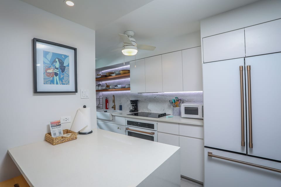 Fully equipped kitchen with toaster, microwave, blender, and spices.