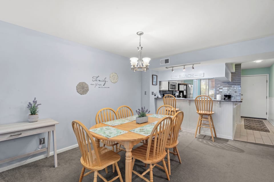 Gather around this inviting dining table for shared meals and laughter. The open layout connects seamlessly to your fully equipped kitchen, making hosting effortless.