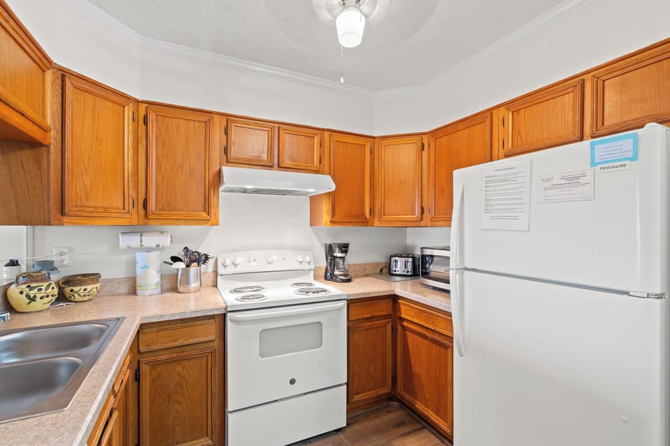 Prepare your favorite meals in this fully equipped kitchen featuring warm wood cabinets and all essential appliances for your stay.