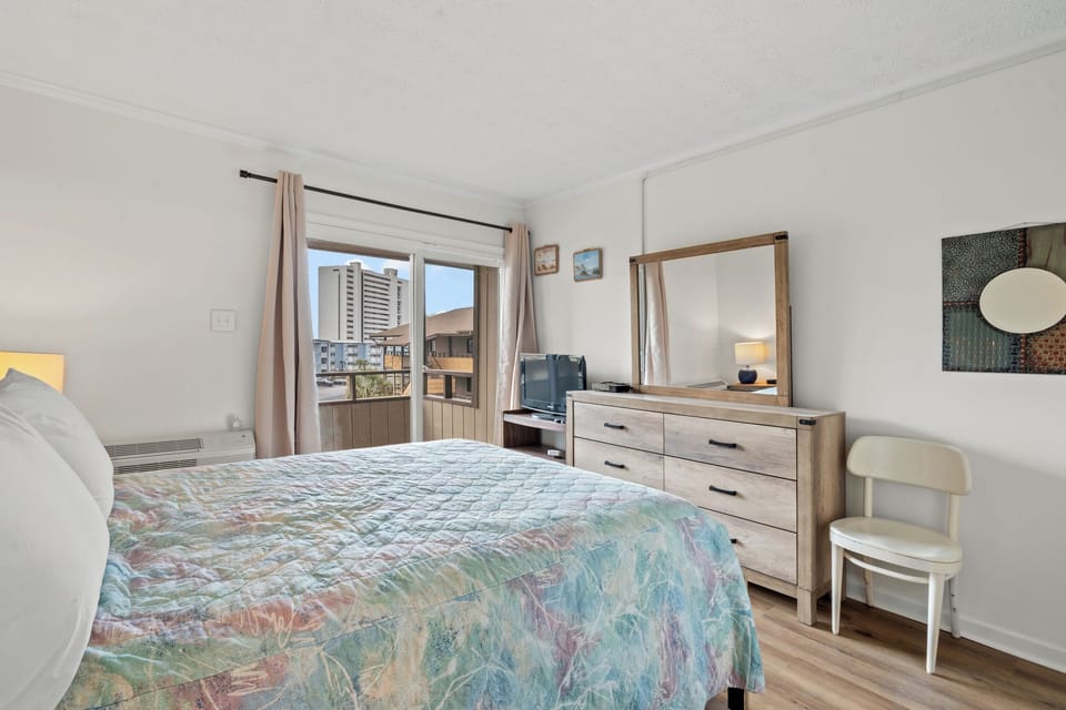 Wake up to city views from your comfortable bedroom featuring modern furnishings and abundant natural light streaming through large windows.