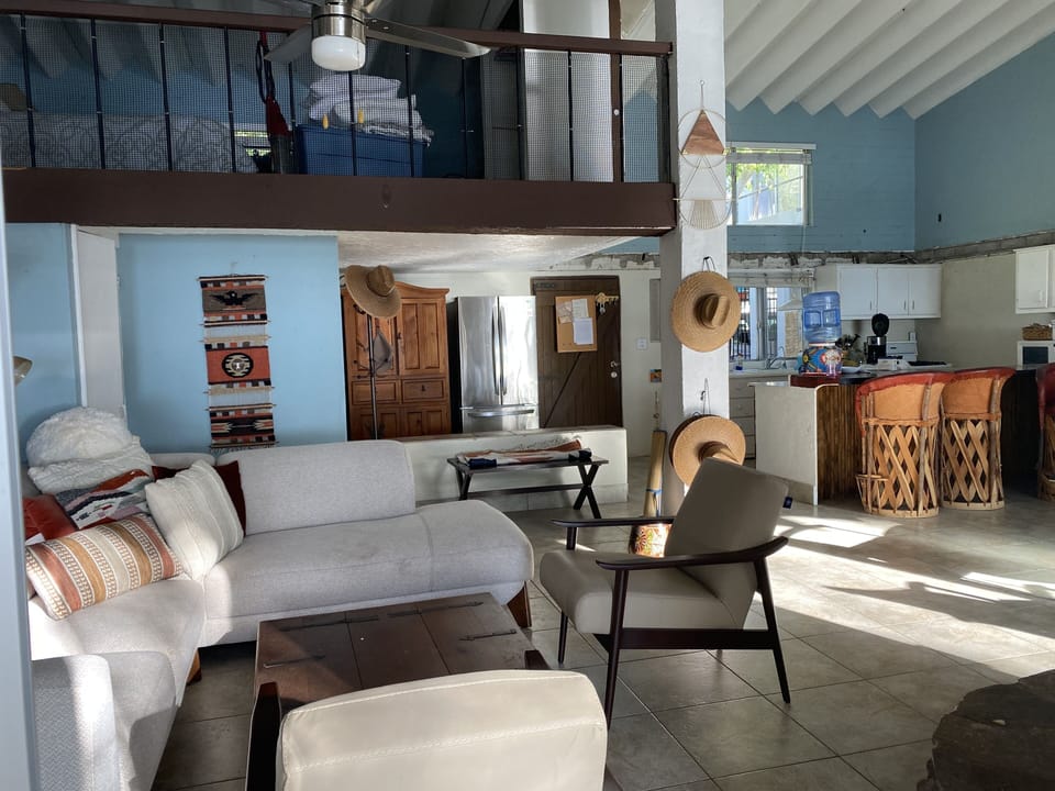 Living area with sectional and Loft overlooking the sea  with a queen bed.