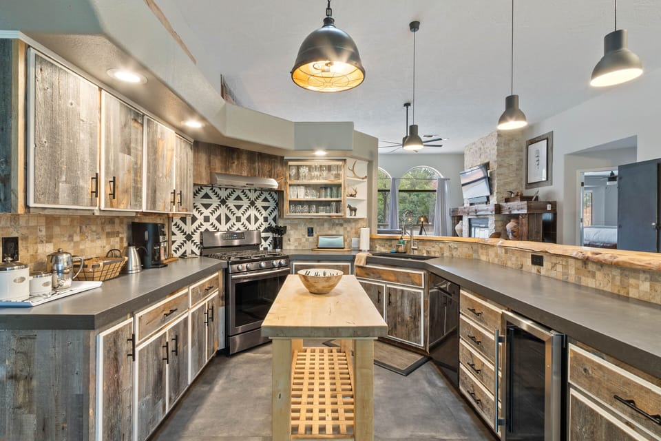 A Multitude of Textures and Finishes Including Stone Countertops, Lovely Tile, Custom Cabinets, and a Butcher Block Island