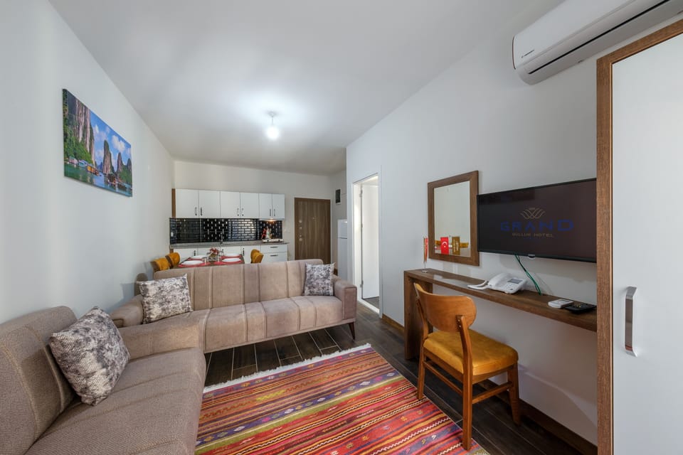 Deluxe Suite | Living room | 28-inch LCD TV with satellite channels, TV
