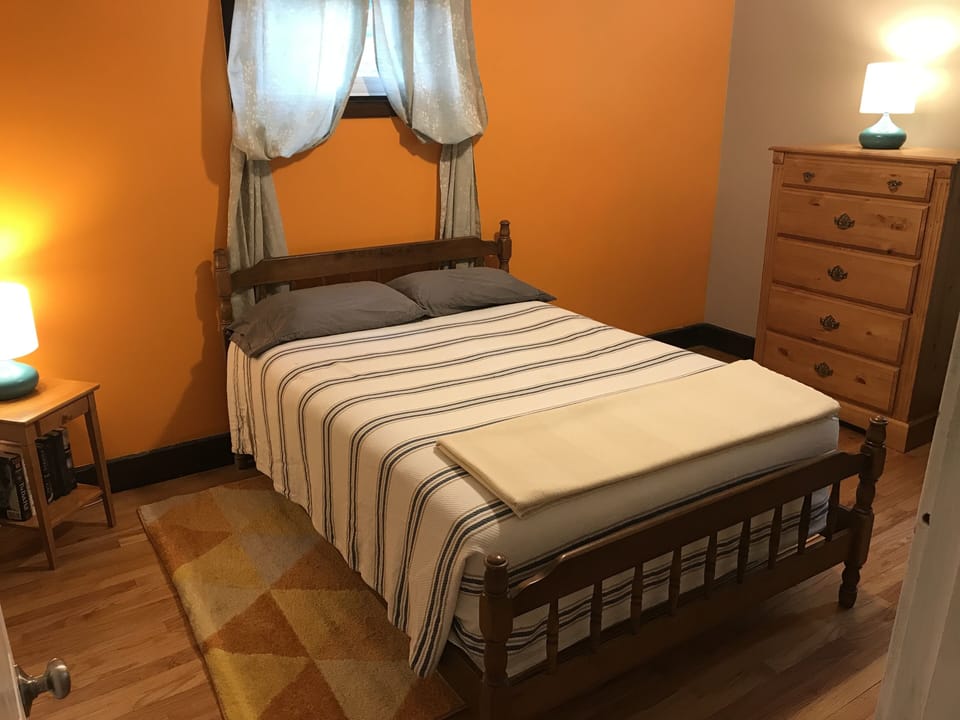 The orange accented bedroom with full sized bed.  