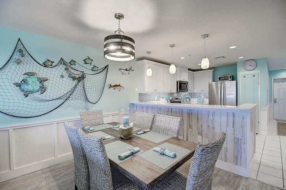 Dining Area — Wicker Chairs, Wooden Table, Fishing Net & Sea Turtle Decor, Drum Chandelier