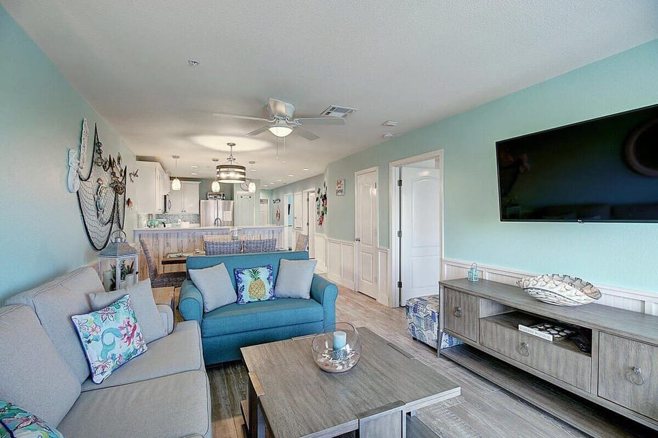 Living Room — Gray Sofa, Teal Loveseat, Pineapple Pillow, Fishing Net Decor & TV
