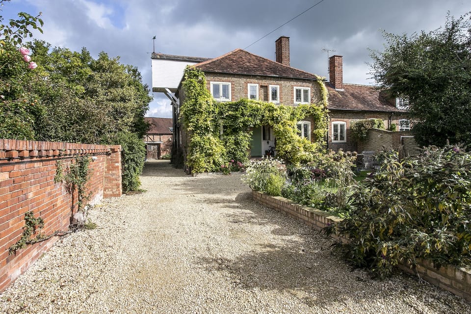 View of main house and gravelled driveway to the apartment on the left at rear. 