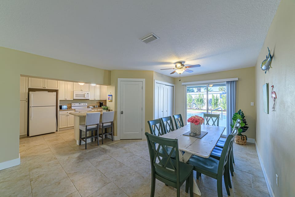 Dining room seats 8, open to kitchen and overlooking the pool