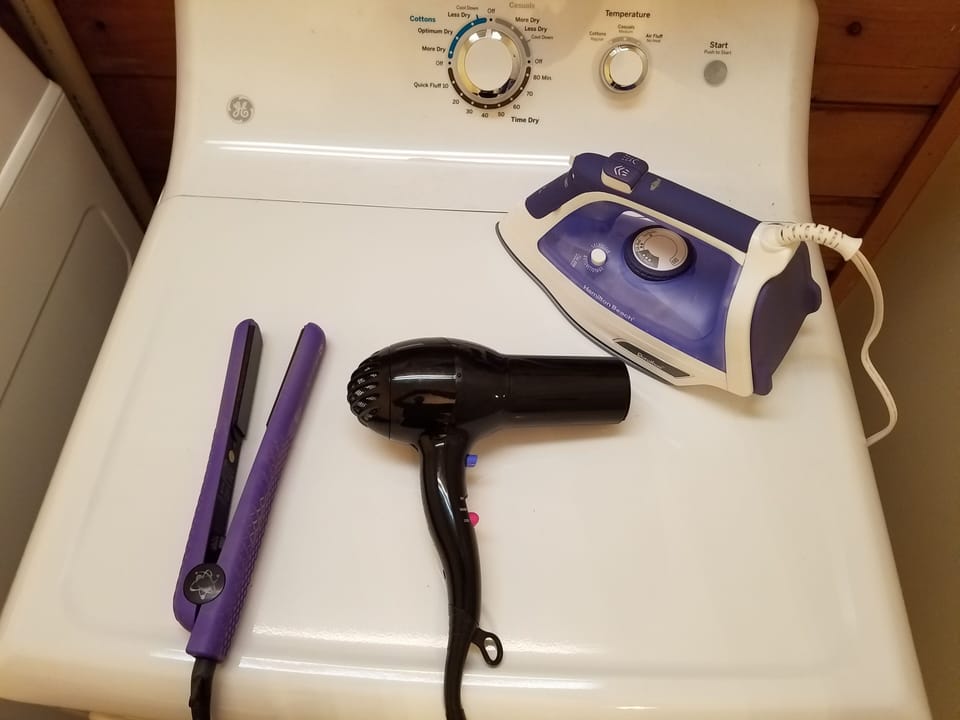 Blow dryer, straightener, iron in master bathroom. 