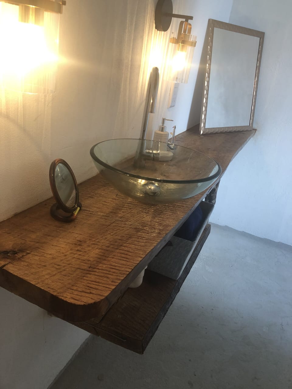 The bathroom vanity is live edge wood. Glass bowl sink and toilet.
