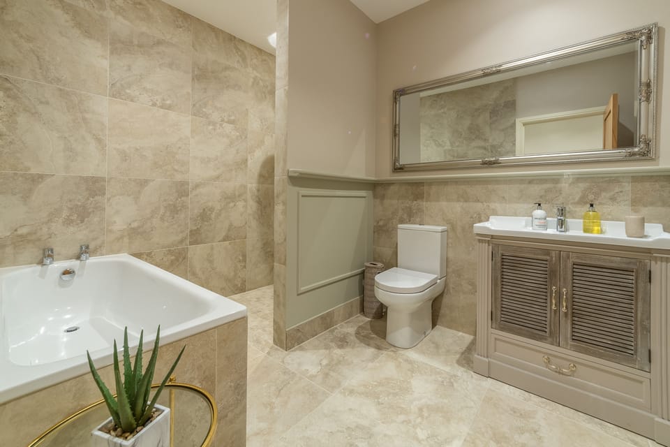 Ground floor: En-suite to bedroom two with bath, basin, deluxe shower and WC