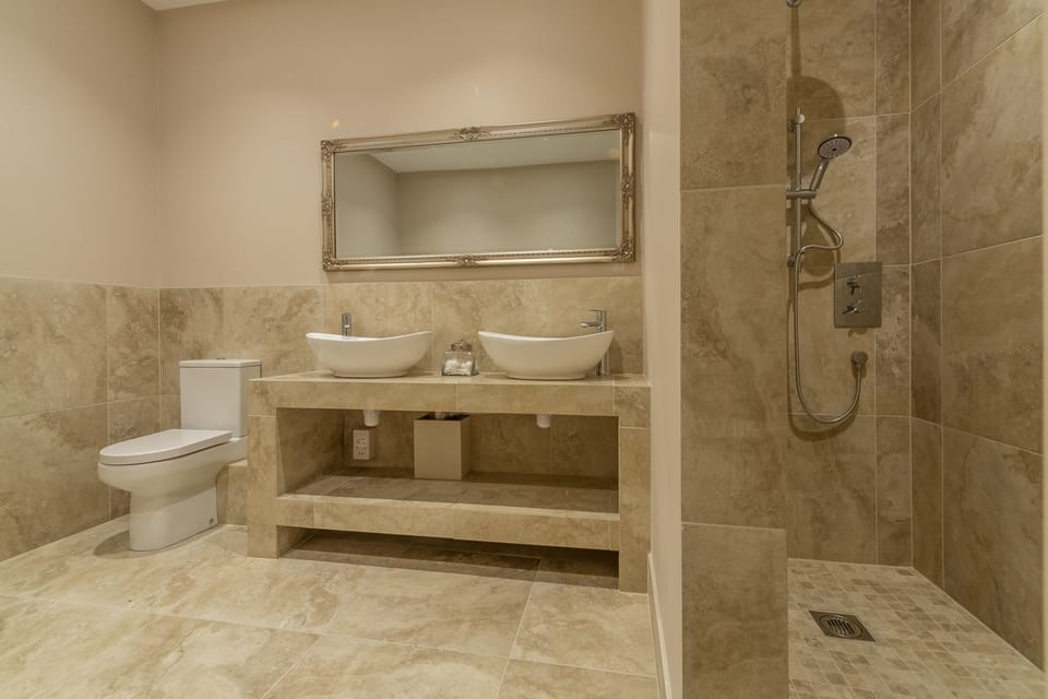 Ground floor: En-suite to master bedroom with double ended slipper bath, luxury walk-in shower, double basins, WC and heated hand rail