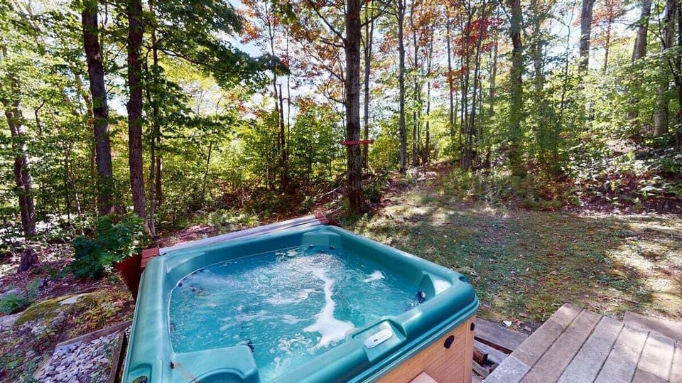 Private hot tub set in a wooded outdoor space for year round soaking.
