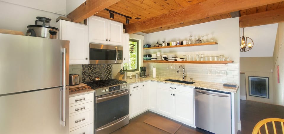 Kitchen corner view highlighting the gas stove, counters, and open shelving.