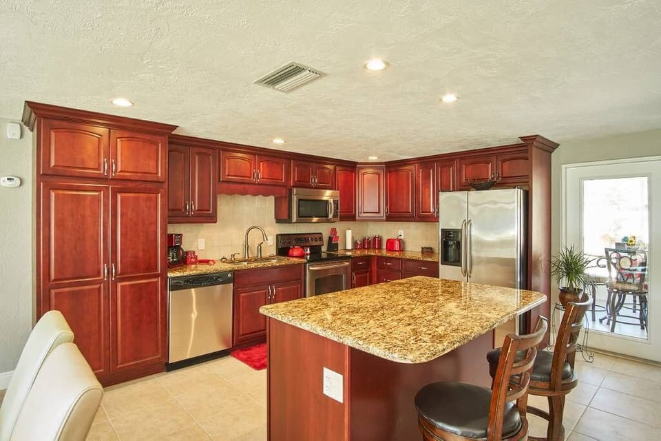 Large open kitchen: stainless appliances, granite countertops, fully furnished.