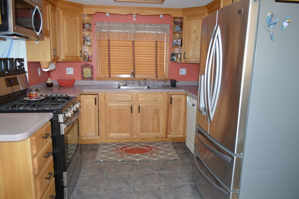 Gourmet stocked kitchen with big refrigerator and gas stove.