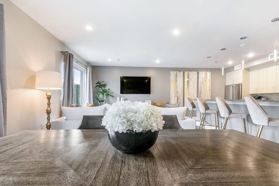 Open-concept living, kitchen, and dining area with plenty of seating. Enjoy a 65” Samsung Smart 4K TV with streaming and DIRECTV Entertainment. Dining table for six and bar seating for four. Lots of natural light too!
