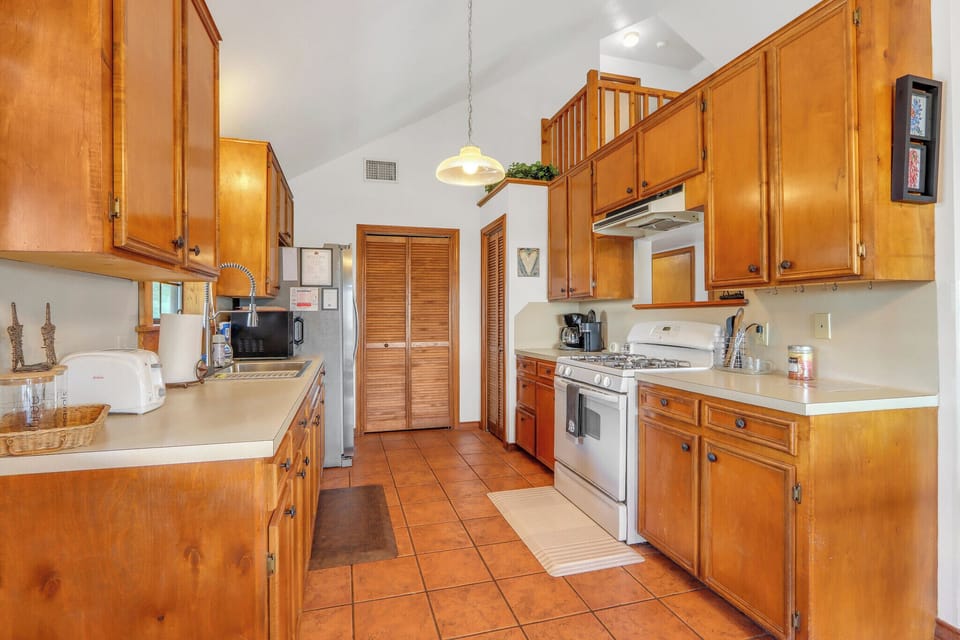The kitchen is stocked with oven, stove, refrigerator, and microwave