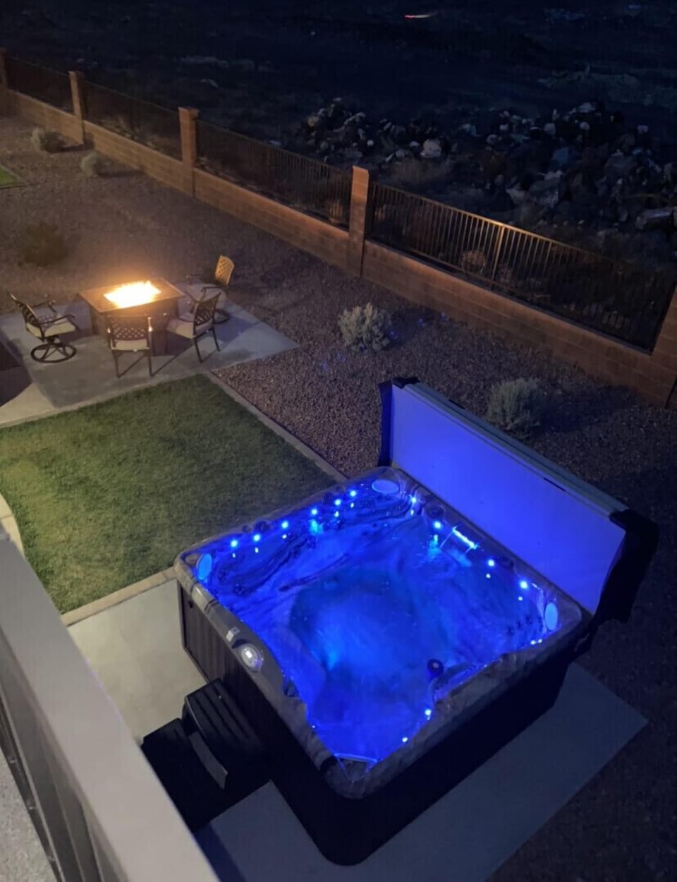 Looking down into backyard from upstairs patio to see hot tub and fire pit 