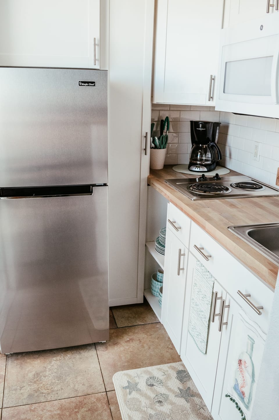 Stainless refrigerator, stove-top, microwave and coffee pot .