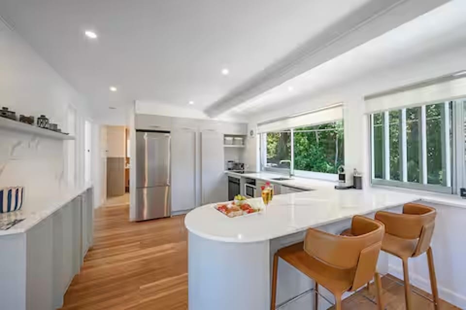 Curved benchtops, stools, full appliances and Nespresso suit easy meals at home.