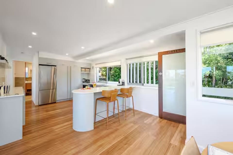 Kitchen, dining, breakfast bar, and lounge connect in one open-plan living zone.