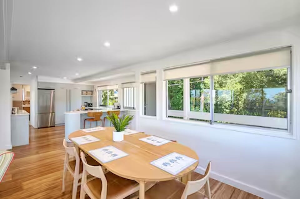 Noosa Escape dining sits by the kitchen, with leafy Little Cove outlooks nearby.