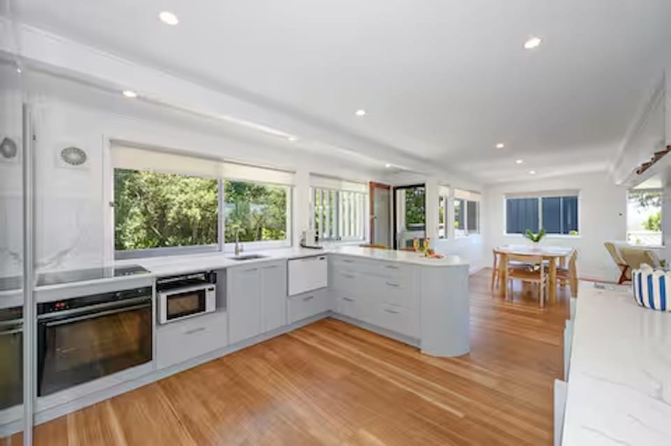 Full appliances, island bench, stools, and Nespresso make the kitchen practical.